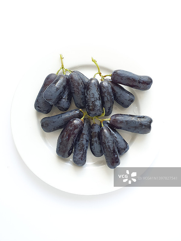 白色背景下白色碗中甜蜜蓝宝石葡萄特写图片素材