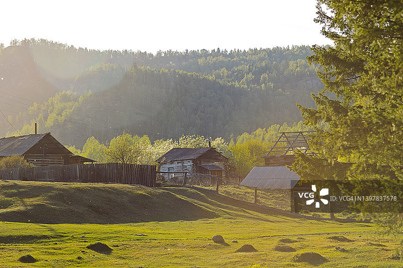 俄罗斯阿尔泰山村庄的古老农舍，春季景色图片素材