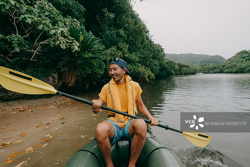 男人在红树林河流上玩充气筏，享受乐趣图片素材