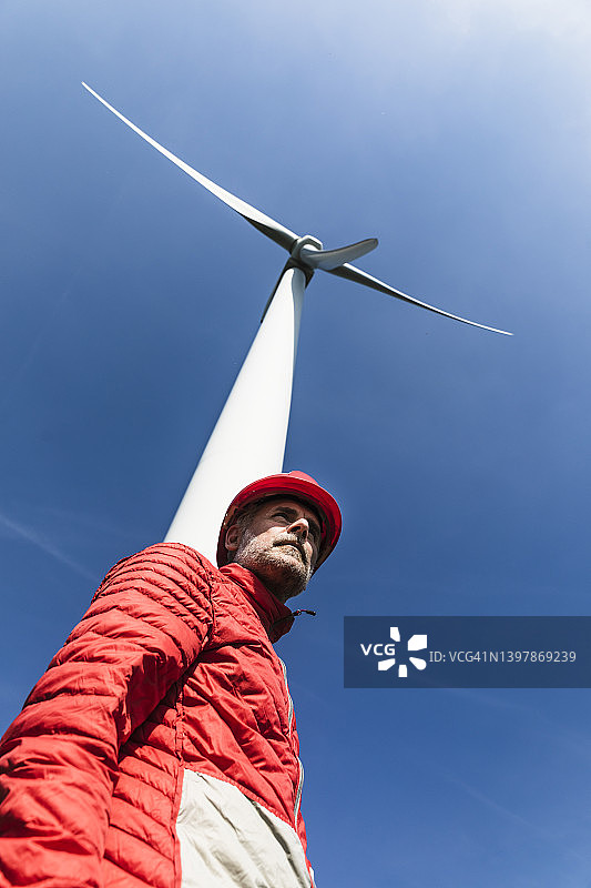 维护工人和风力涡轮机，底部视角图片素材