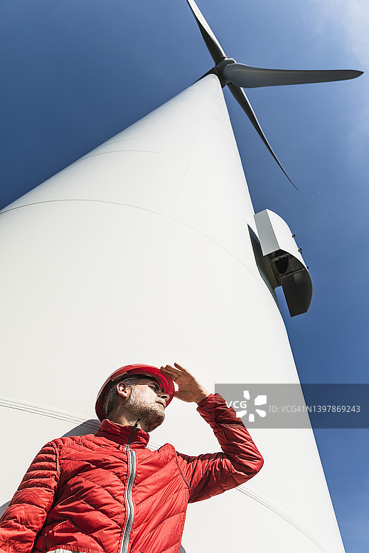 工程师和风力涡轮机，仰视图片素材