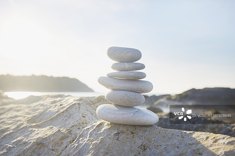 海滩上晴空下的平衡石堆图片素材