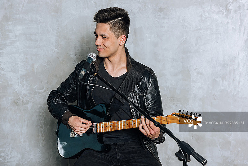 英俊的男人弹吉他唱歌图片素材