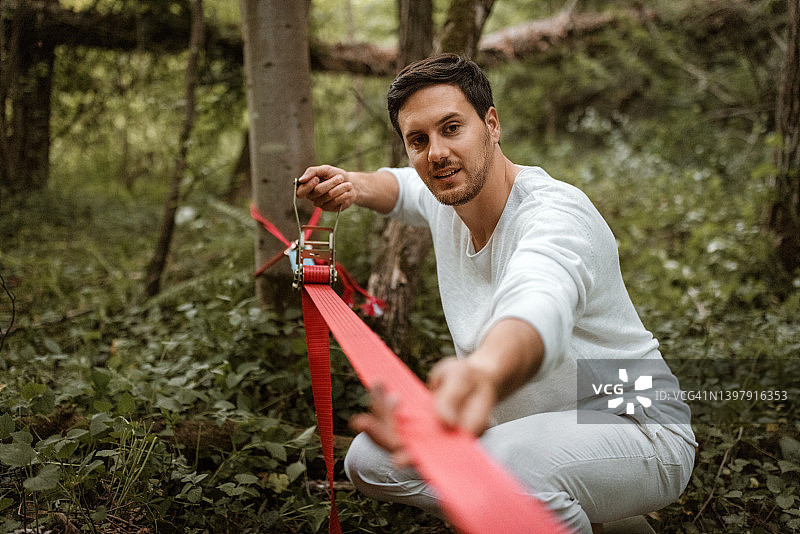 年轻男子在森林中准备平衡训练的走扁带图片素材
