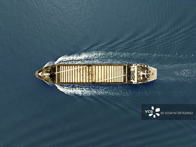在波涛汹涌的海面上航行的散货船（航拍视角）图片素材