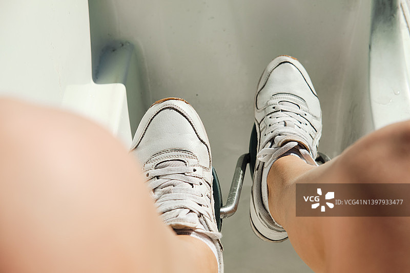 穿着运动鞋的女人在双体船的踏板上，夏季阳光明媚的天气里在湖或海上乘船旅行图片素材