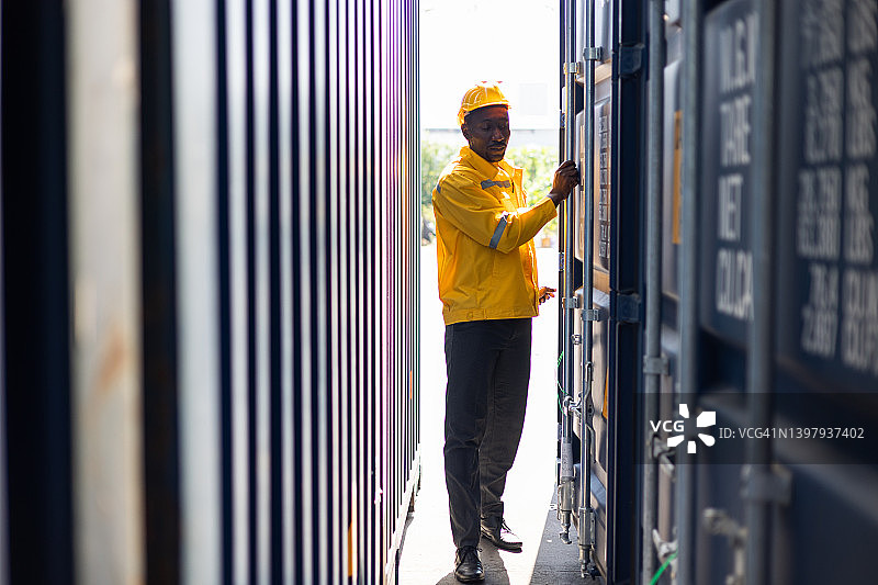 货运站的运输工人正在检查时间表集装箱运输货物。图片素材