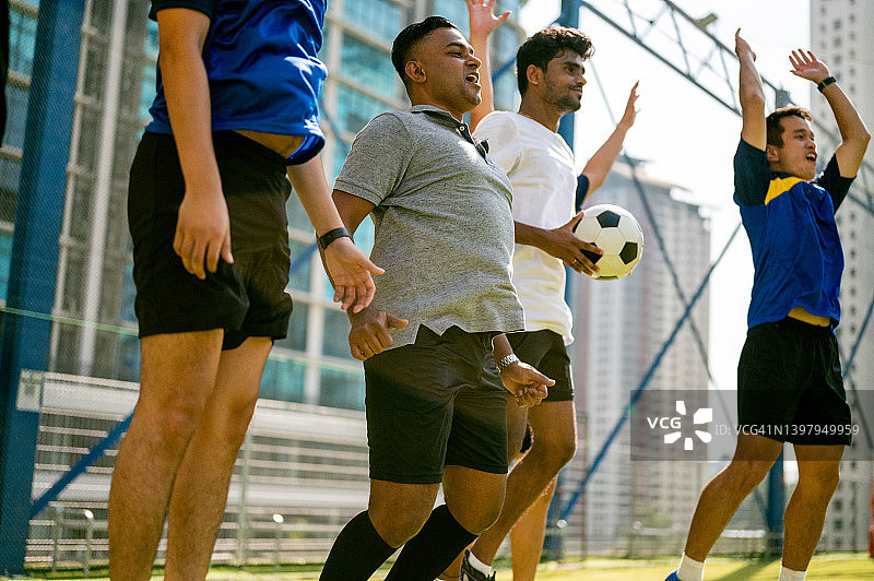 进球！快乐的足球队在球场上庆祝进球图片素材