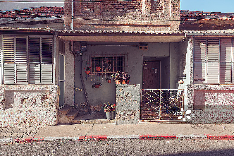 老旧房屋裂墙盆栽百叶窗正面图片素材