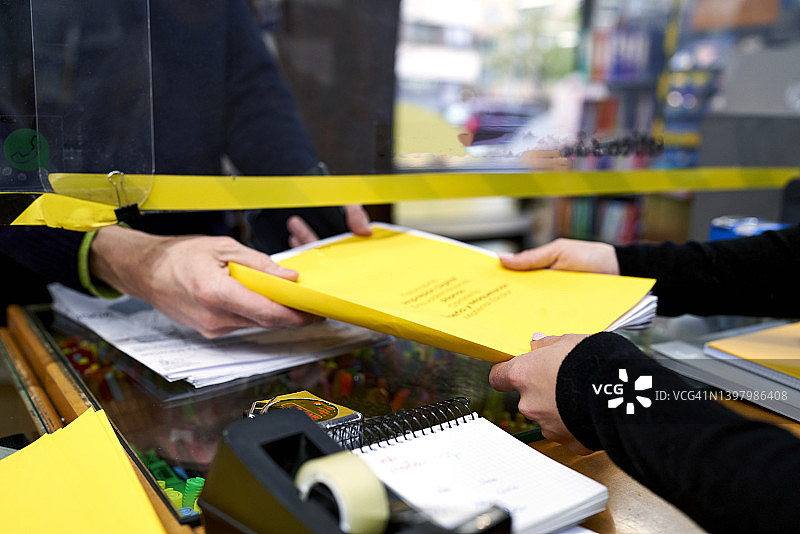 文具店或印刷店员工将完成的作业交给客户图片素材
