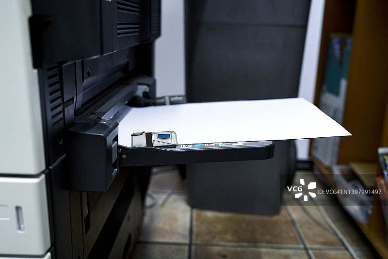 工作场所办公室打印机上的空白白色纸张。商业、办公用品和技术概念图片素材