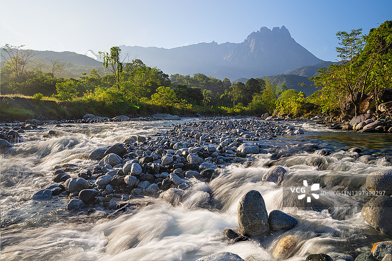 河流中的水流与远处的基纳巴卢山图片素材