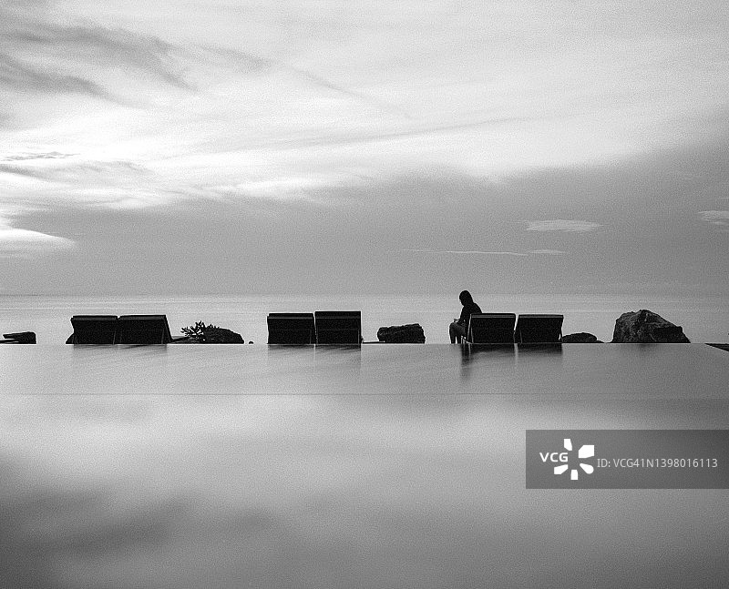 海滩无边泳池中的天空倒影图片素材