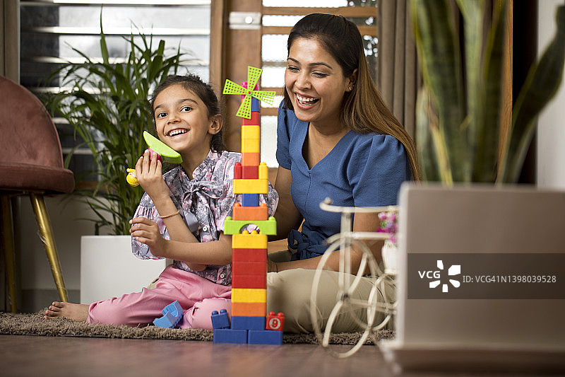 快乐的母女在家玩玩具积木图片素材
