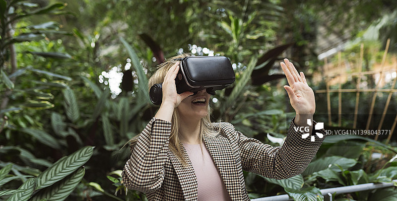 在虚拟现实中玩耍的花园女商人图片素材