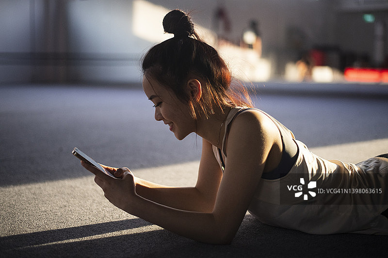 健身后使用手机的亚洲女孩图片素材