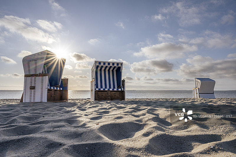 德国石勒苏益格-荷尔斯泰因州霍努姆沙滩上的带罩沙滩椅图片素材