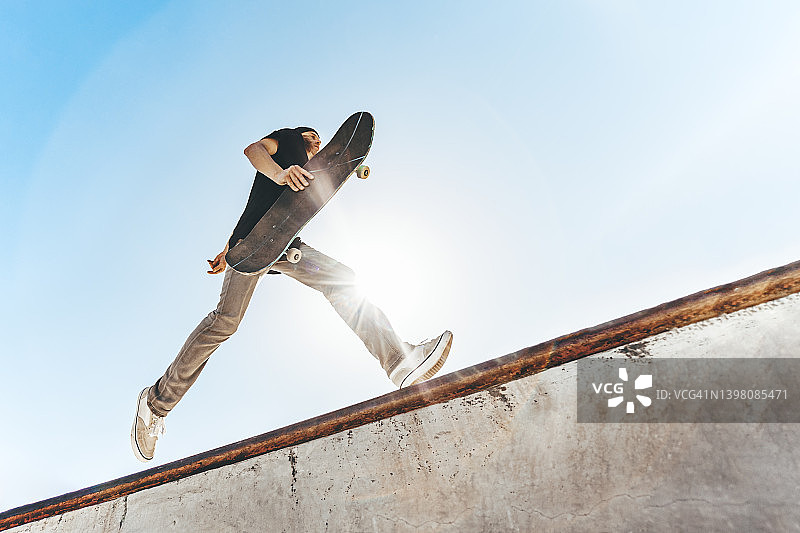 晴天在滑板公园玩滑板的男人图片素材