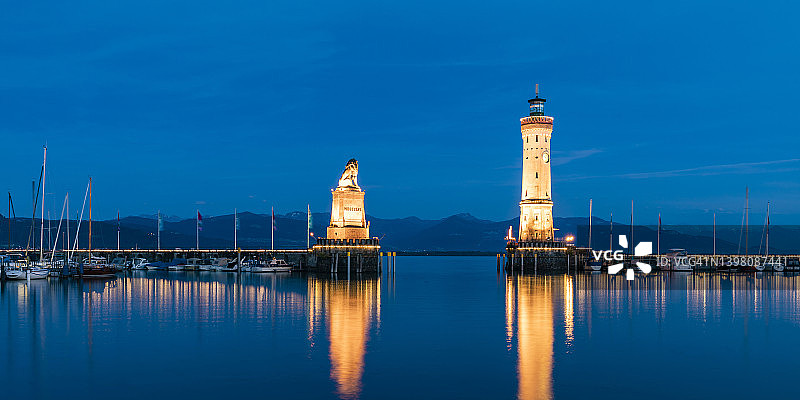 德国巴伐利亚林道，夜晚灯塔和巴伐利亚狮子雕塑的长时间曝光图片素材