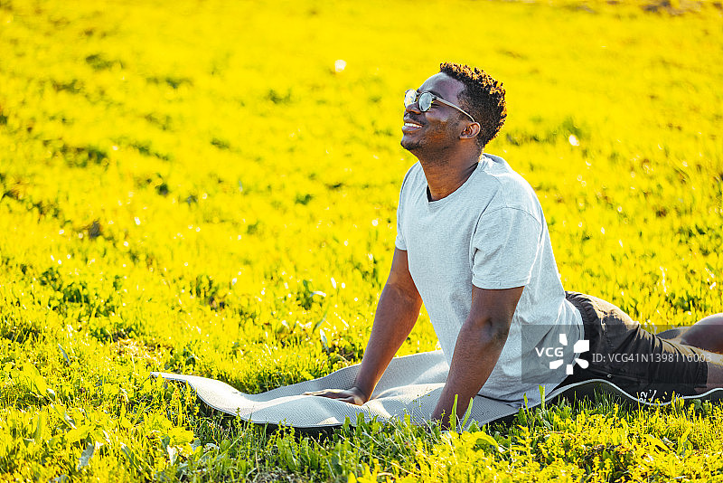 年轻男人在瑜伽垫上做眼镜蛇式伸展运动图片素材