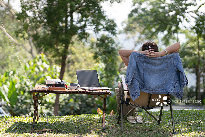 露营假期坐在营地旁边的女子背影图片素材