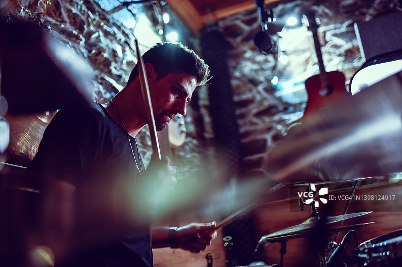 男鼓手在工作室练习时演奏歌曲图片素材