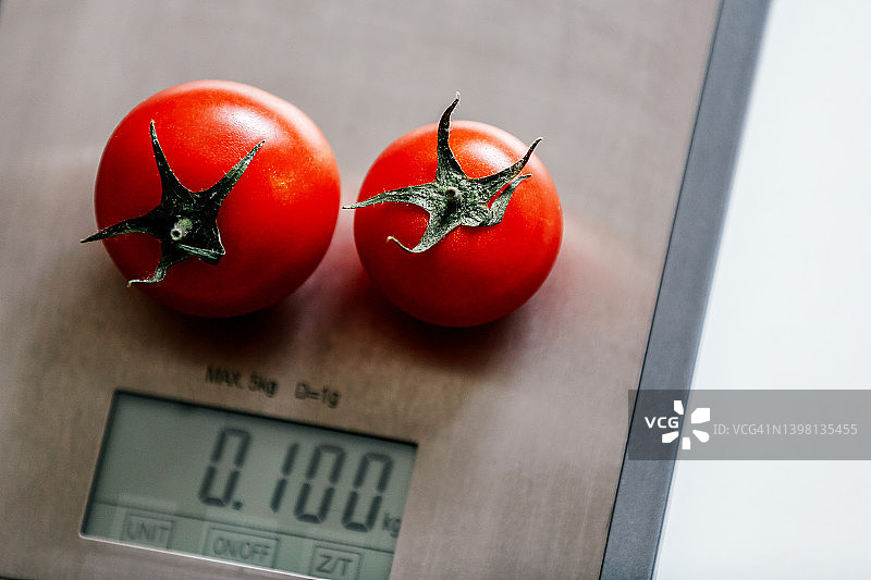 厨房秤上的两个红色新鲜番茄图片素材