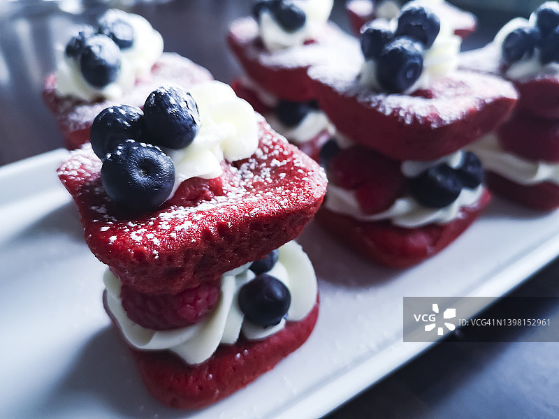 白色盘子上带有蓝莓的红色天鹅绒糕点图片素材