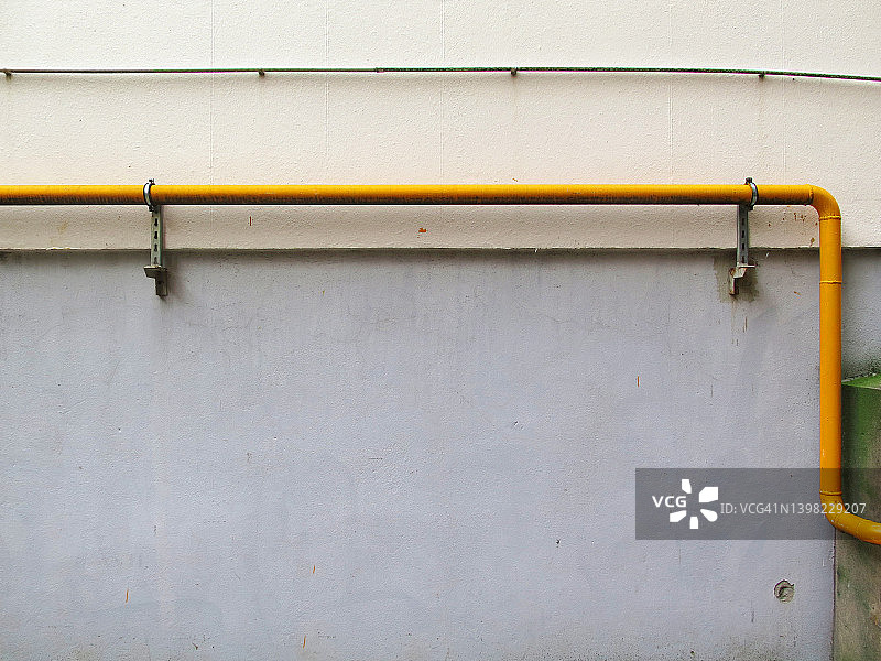 巴黎：带有黄色管道和电缆的灰色混凝土墙图片素材