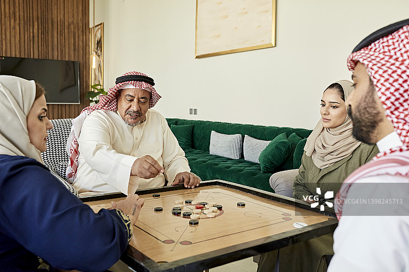 中东家庭在家玩卡罗姆棋图片素材