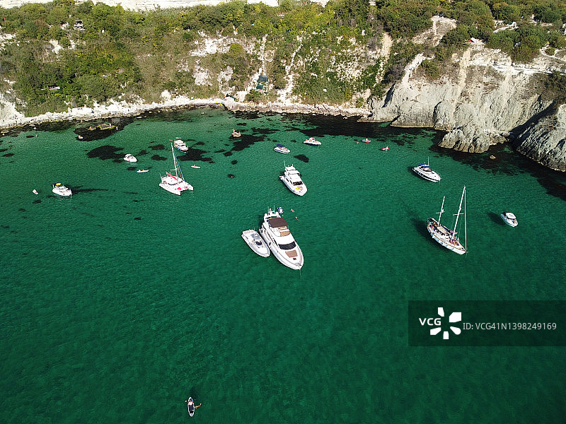 海景航拍全景：水晶般清澈的碧海和岩石海岸，泻湖上的游艇图片素材