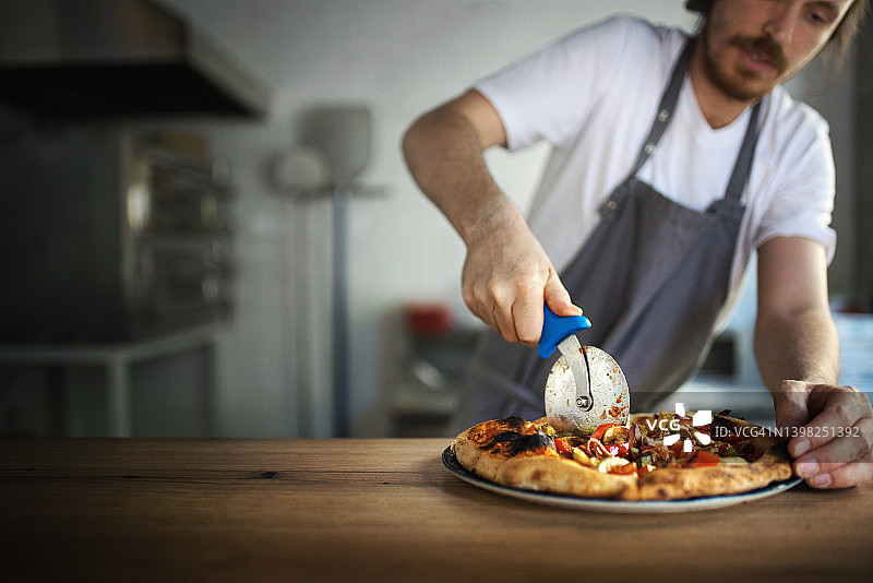 披萨厨师端上新鲜出炉的披萨图片素材