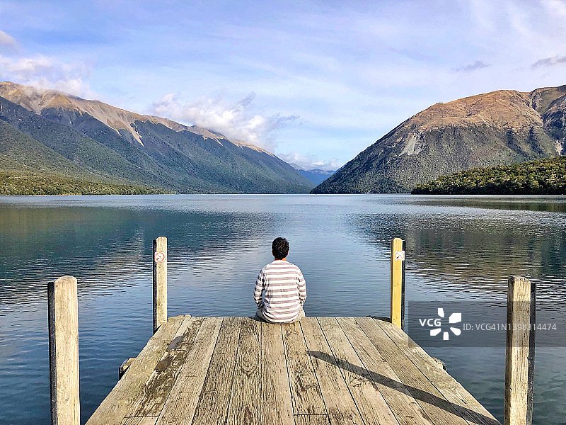 坐在罗托伊蒂湖前的男人背影图片素材