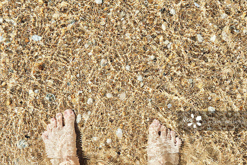 阳光明媚的夏季海滩度假：女性腿部特写第一人称视角图片素材