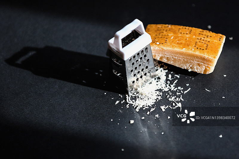 帕尔马干酪和奶酪刨丝器，黑色背景图片素材