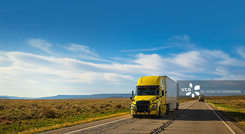 在亚利桑那州疾驰的冷藏货运大黄卡车图片素材