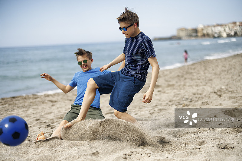 青少年在西西里小镇的海滩上踢足球图片素材