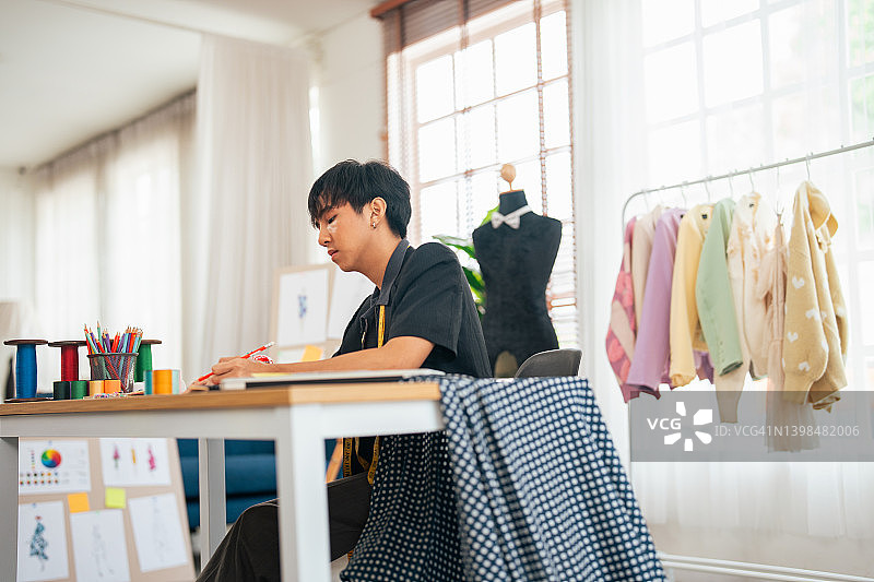 年轻服装设计师在纸上绘制新想法图片素材