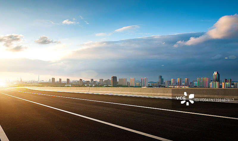 傍晚晴空下通往城市的沥青公路图片素材