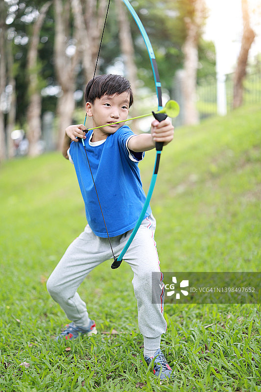 小男孩在公园射箭图片素材