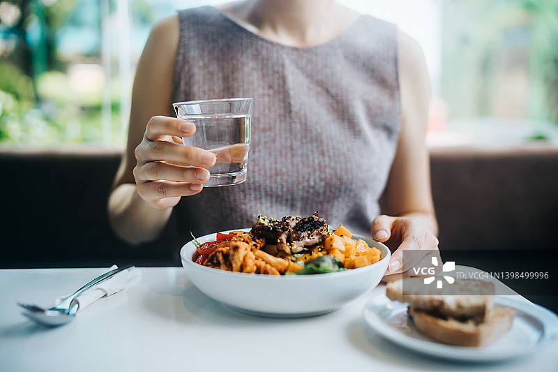 年轻亚洲女人在咖啡馆享用健康餐图片素材