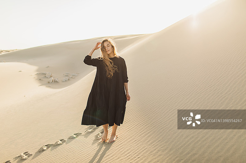 沙漠中的黑色连衣裙美女图片素材