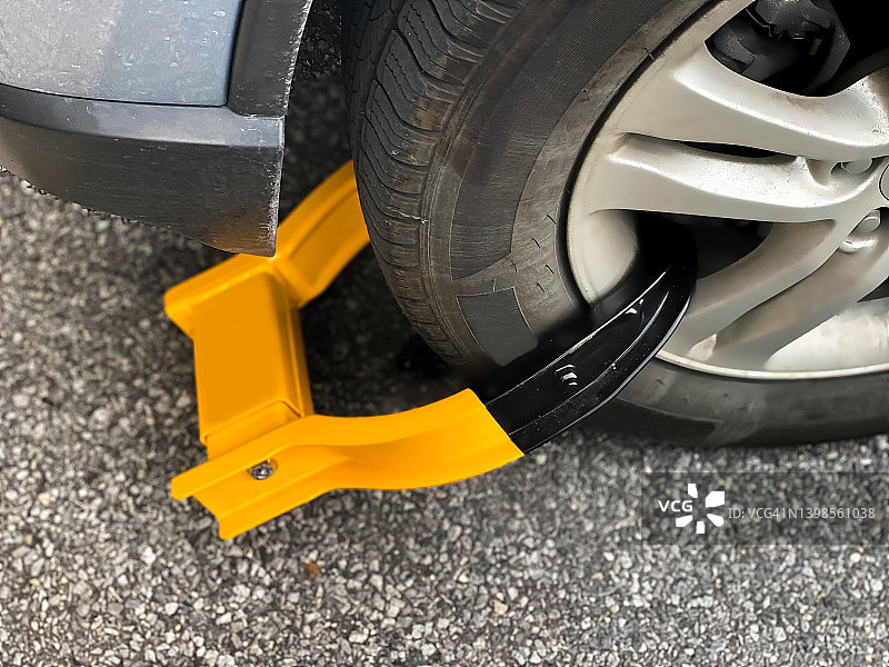 车轮锁：前车轮上的亮橙色固定装置图片素材