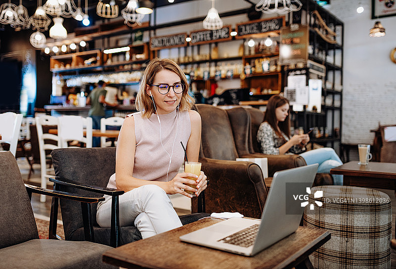 成功的女商人从咖啡馆工作。女性正在参加视频会议图片素材