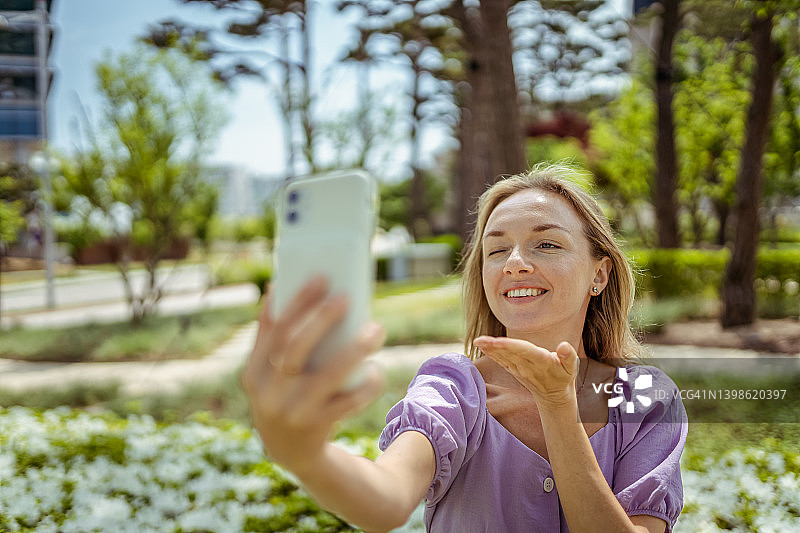 在户外使用手机拍照的美丽女人图片素材