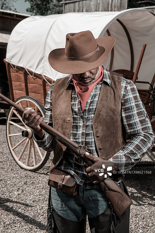 狂野西部背景下的英俊黑人牛仔图片素材
