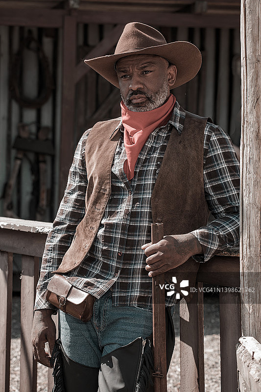 狂野西部背景下的英俊黑人牛仔图片素材