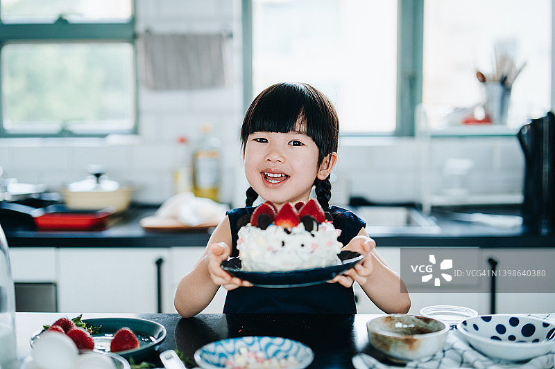 微笑亚洲小女孩手持装饰奶油蛋糕图片素材