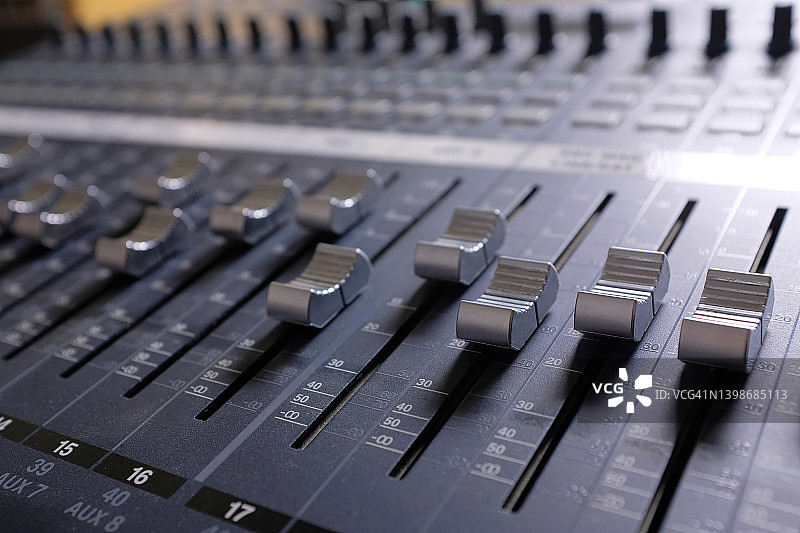 放大设备，工作室音频混音器旋钮和推子，音响工程师的工作场所和设备，音乐的声学混合，选择性聚焦图片素材