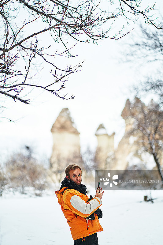 男游客用智能手机看着镜头图片素材